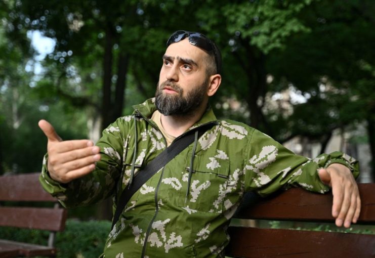 Islam, a Chechen volunteer fighter, sitting on a bench