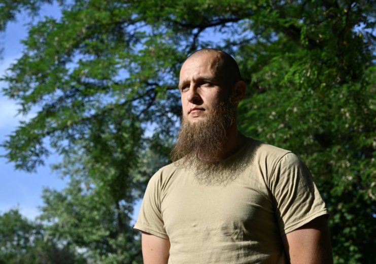 Asadulla, a Chechen volunteer fighter, standing outside