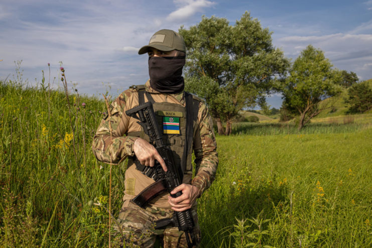 Maga, a Chechen volunteer, standing with his firearm