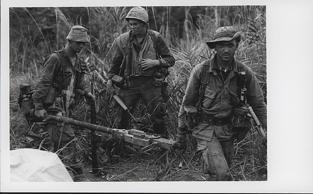 Three Marines carrying a DHsK