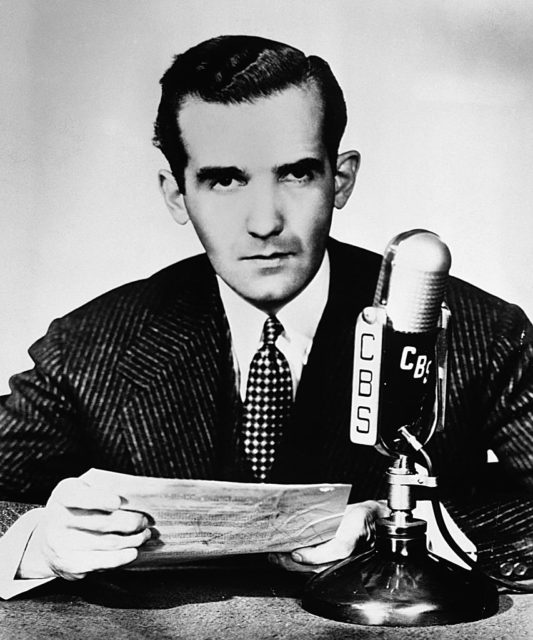 Edward R. Murrow sitting behind a microphone at a desk