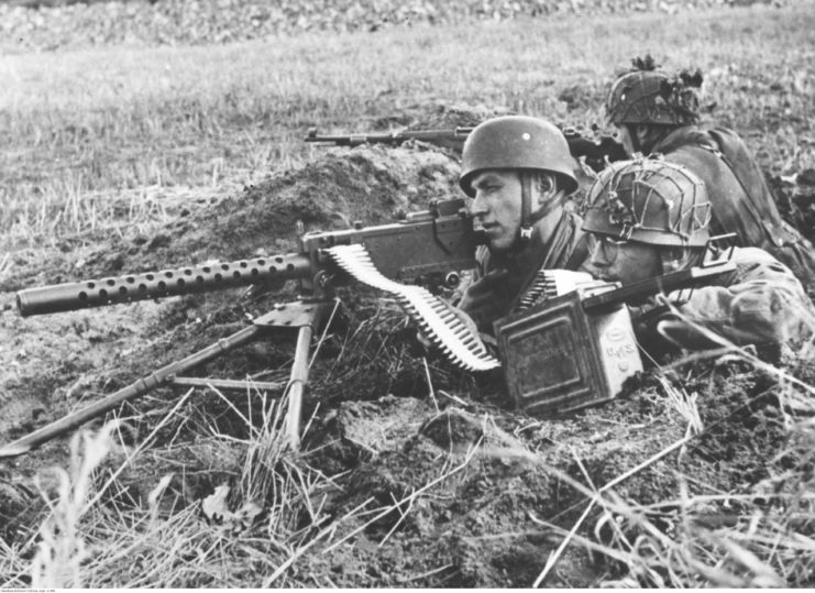 Three German soldiers operating an M1919 Browning from a small ditch