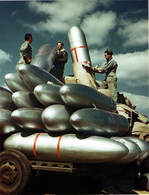 Three tech supply men standing on top of a pile of "papier-mâché" fuel tanks