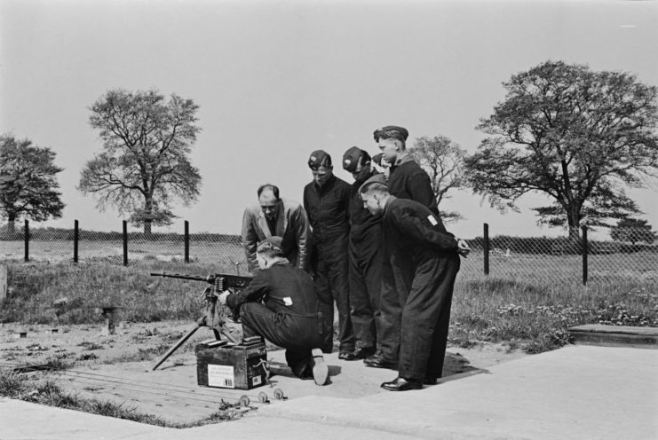 Officers crouched around an instructor manning an M1919 Browning