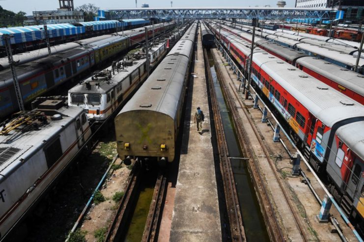 Aerial view of a man walking along the side of trains