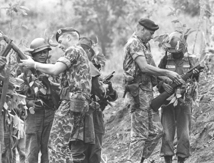 US Green Berets holding firearms while speaking with South Vietnamese soldiers