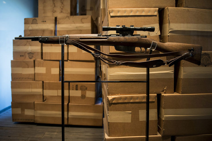 Carcano Model 91/38 on display in front of piles of cardboard boxes