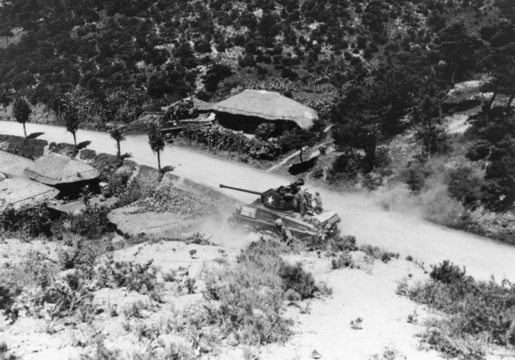 Aerial view of a tank driving along a dirt road