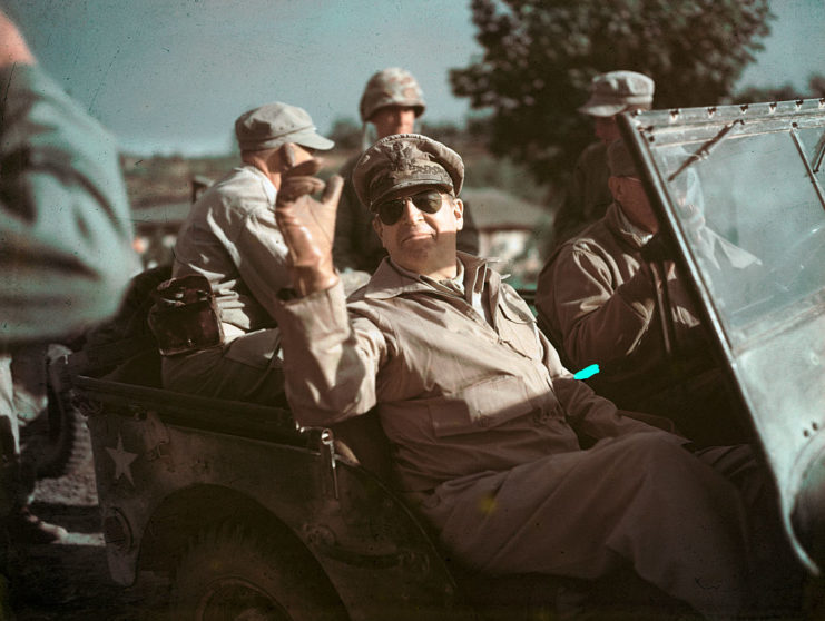 Douglas MacArthur riding as a passenger in a military Jeep