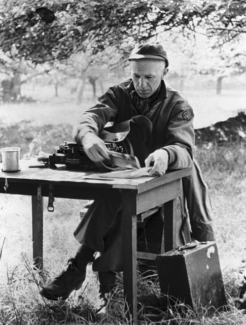 Ernie Pyle sitting at a desk while in the field