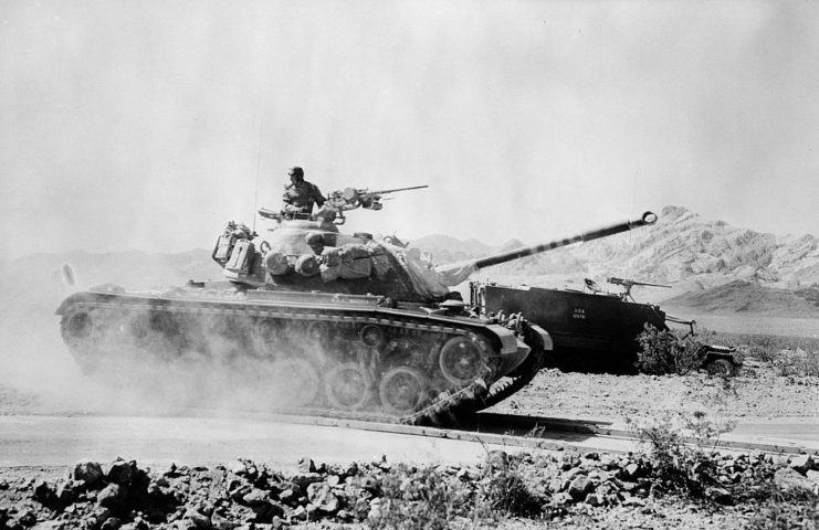 Tank driving down a dirt road