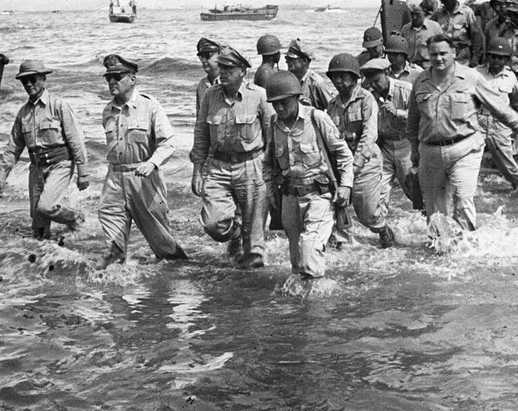 General Douglas McArthur walking through water with US Army and Filipino officers