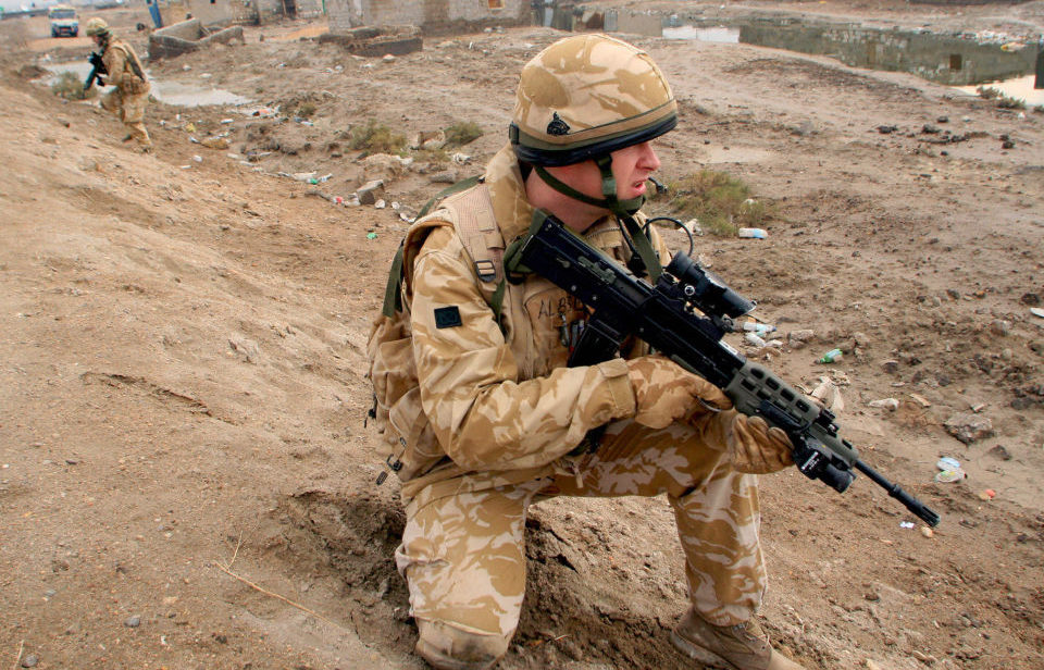 British soldier kneeling while holding his firearm