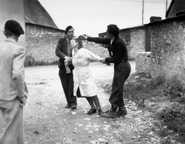 Two men holding a woman by her arms