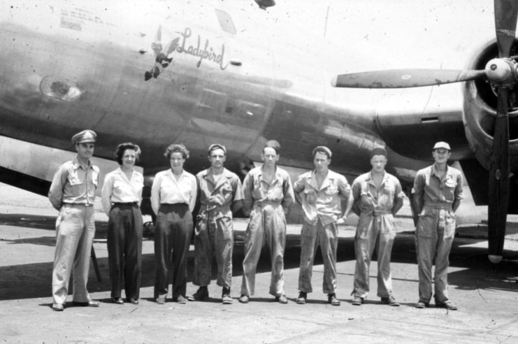 Paul Tibbets, Dora Dougherty Strother and Dorothea Johnson "Didi" Moorman standing with crewmen in front of the "Ladybird"