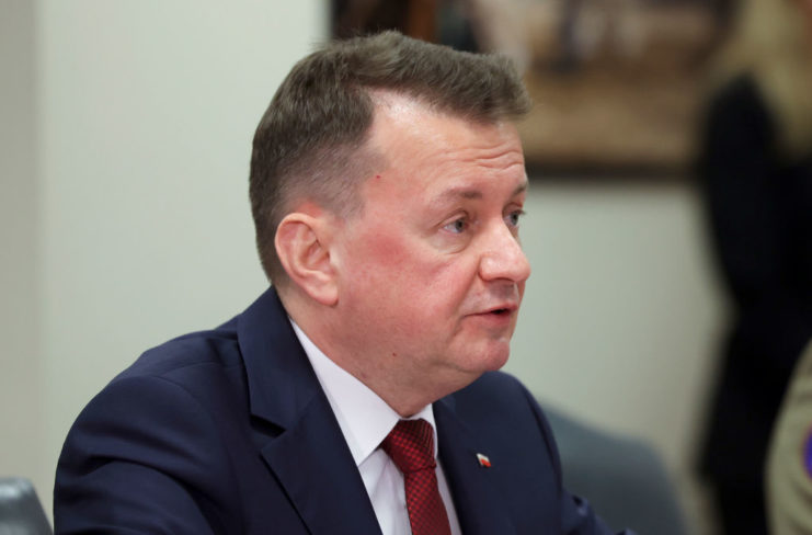 Mariusz Błaszczak sitting at a table