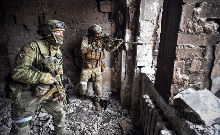 Two Russian soldiers staring out the window of the Mariupol drama theater
