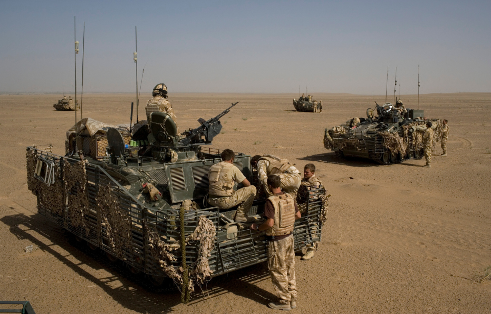 British troops sitting on an armored vehicle in the desert