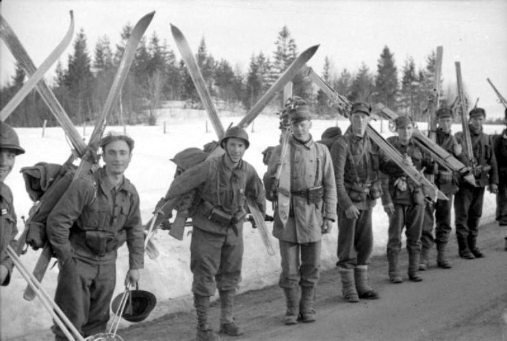 British soldiers standing in a row, with skis on their backs