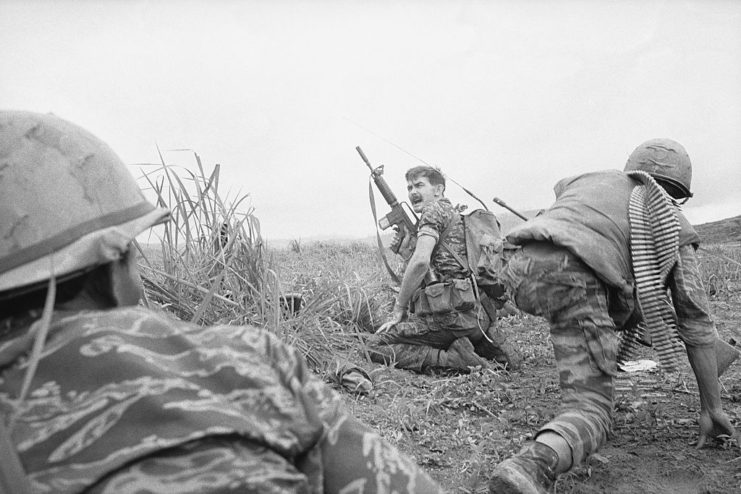 Three US Army Special Forces members kneeling in the grass