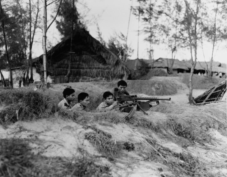 Four Junk Force sailors manning an M1919 Browning from a trench