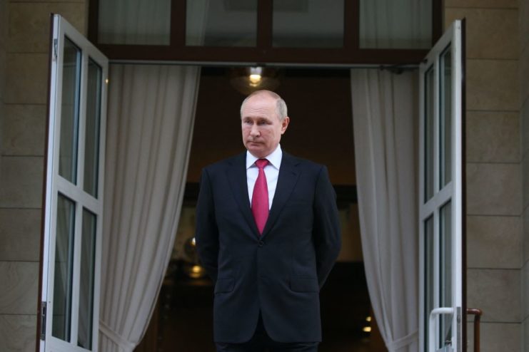 Vladimir Putin standing in front of two open doors