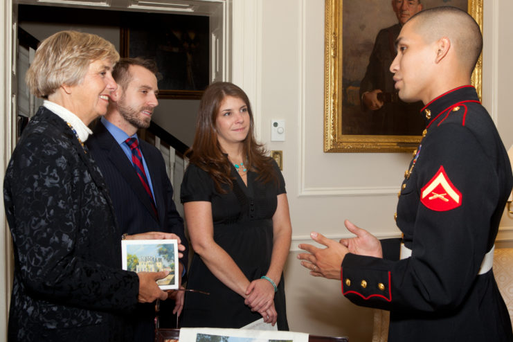 US Marine Corps lance corporal speaking to two women and one man