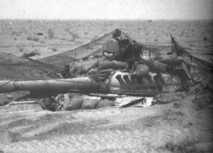 T-72 tank partially submerged in the sand