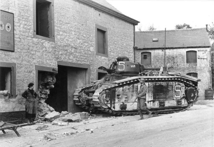 Belgian woman and German soldier staring at a damaged house and abandoned Char B1