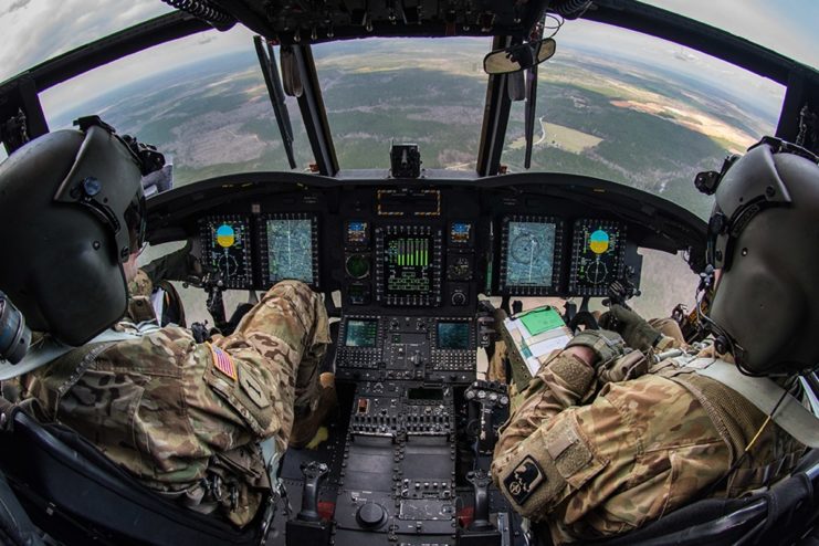 Two pilots sitting in the cockpit of a Boeing CH-47 Chinook helicopter