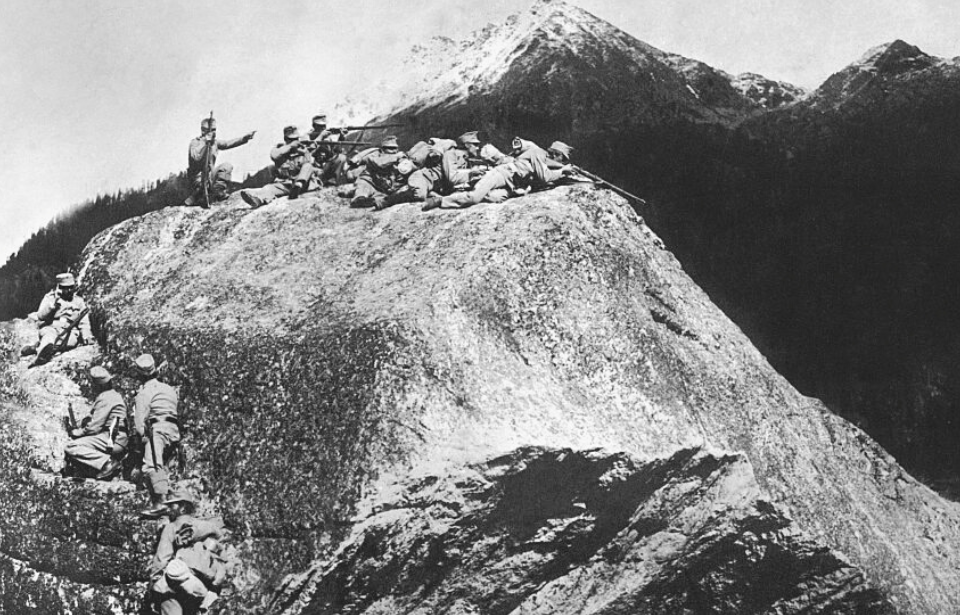 Austrian soldiers take aim with rifles on a mountaintop