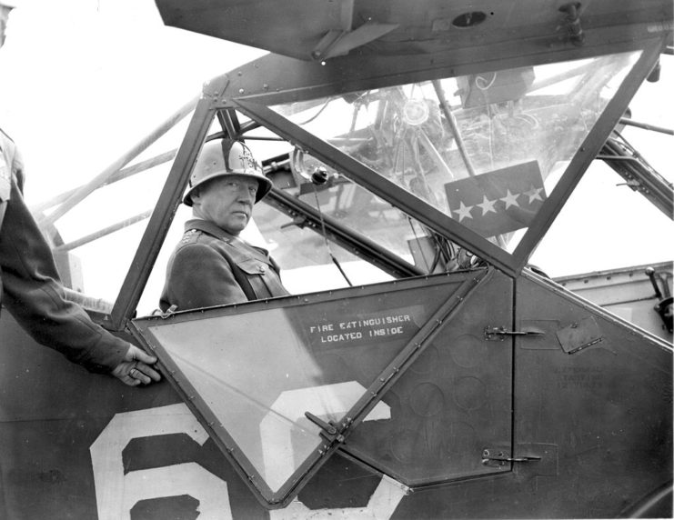 George Patton seated in the cockpit of an airplane