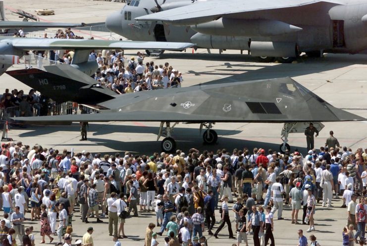 Crowd gathered around a Lockheed F-117 Nighthawk parked on a runway