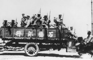 Japanese Army soldiers sitting in the back of a truck
