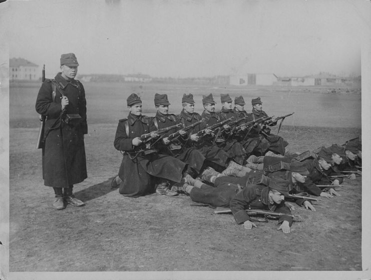 Serbian military recruits standing together with firearms