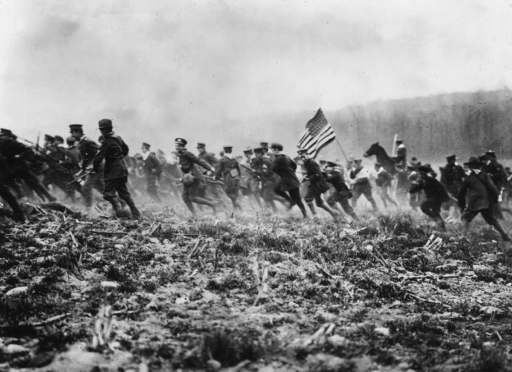 US soldiers running together across a mock battlefield