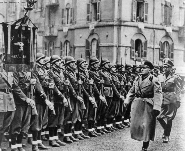 Benito Mussolini walking along a line of shock troops