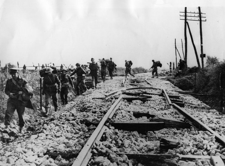 British infantrymen walking along a damaged railroad