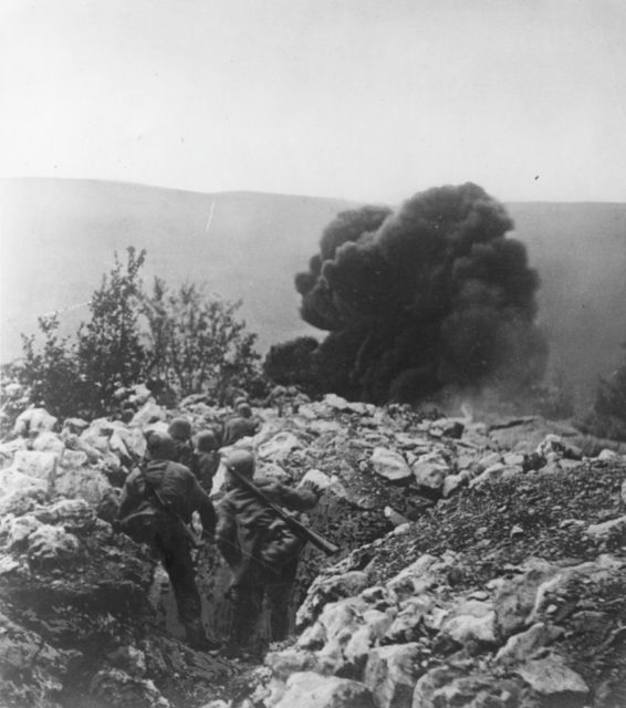 Austro-Hungarian troops looking at a large smoke cloud in the distance
