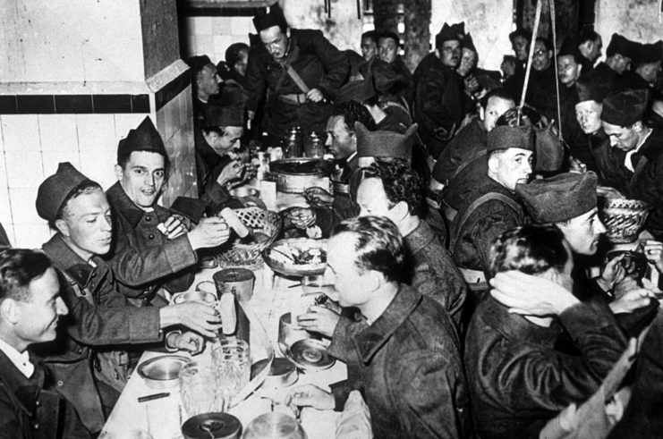 Soldiers sitting at tables, eating a meal
