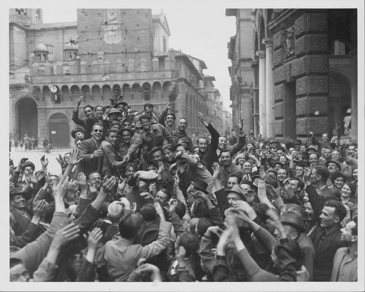 Italian troops surrounded by a large group of civilians