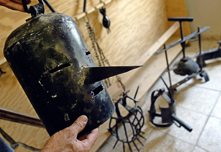 Iraqi Olympic Committee official holding a torture mask