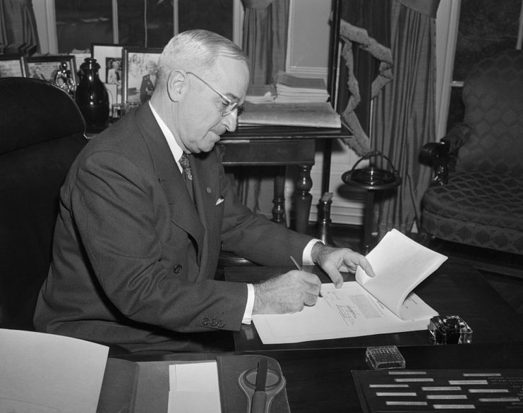 Harry Truman writing a note at his desk