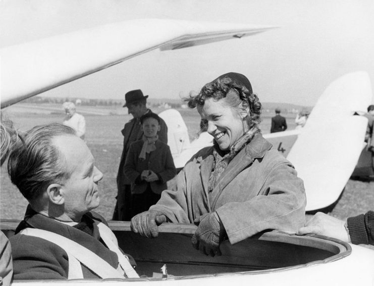 Hanna Reitsch speaking with a pilot who is sitting in the cockpit of an aircraft
