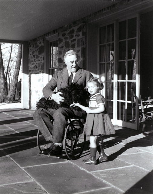 Franklin D. Roosevelt sitting outside with his dog and a little girl