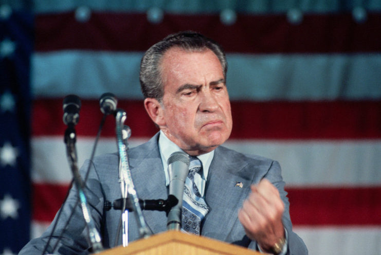 Richard Nixon making a fist while standing at a podium