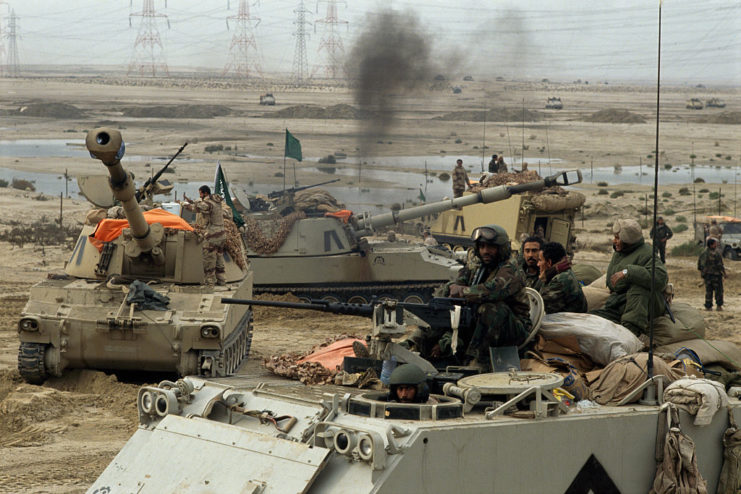 Soldiers sitting on tanks in the desert