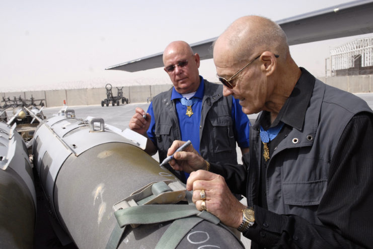 Robert Howard and Gary Littrell signing a 2,000-pound Guided Bomb Unit