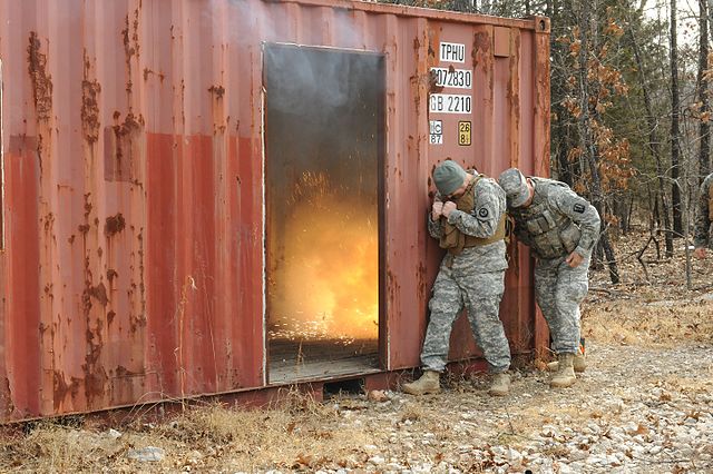 Sgt. Jason Christy and Staff Sgt. Stephen Crowe duking while an M84 stun grenade detonates inside a cargo container