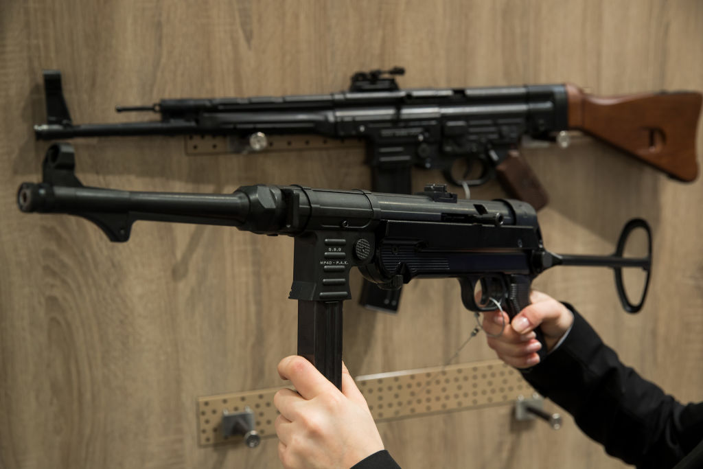 MP 40 being held up in front of another firearm